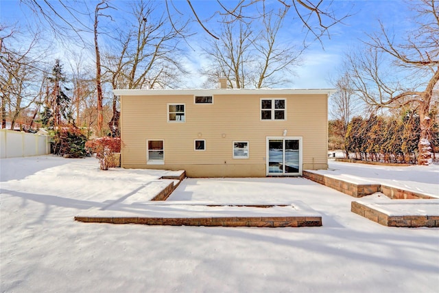 view of snow covered back of property