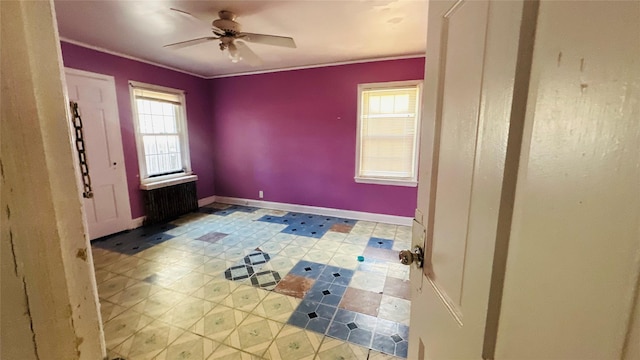 unfurnished room featuring ceiling fan, ornamental molding, and radiator heating unit