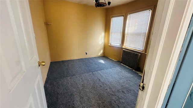 carpeted spare room with radiator heating unit