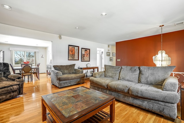 living room featuring a chandelier and light hardwood / wood-style floors