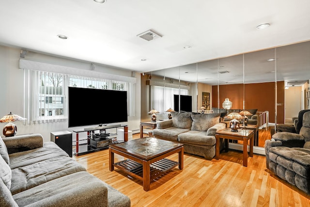 living room featuring a baseboard heating unit and light wood-type flooring