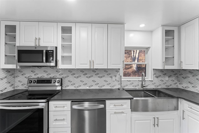 kitchen featuring stainless steel appliances, white cabinetry, sink, and decorative backsplash