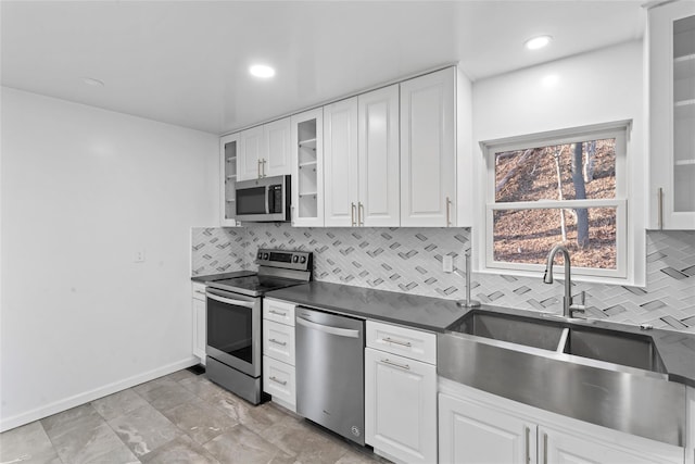 kitchen with white cabinetry, stainless steel appliances, sink, and decorative backsplash