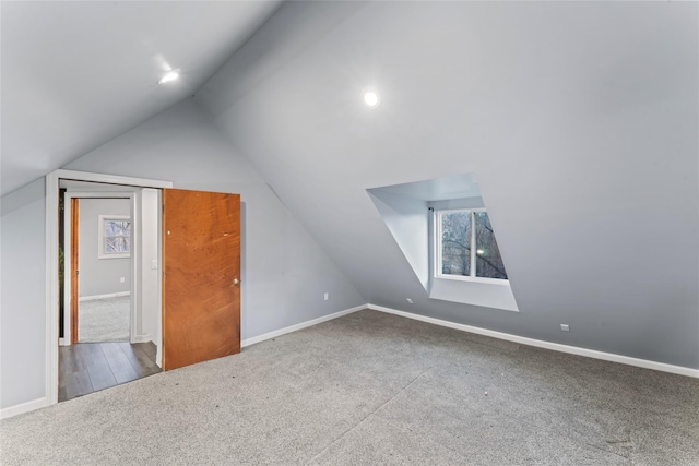 bonus room featuring vaulted ceiling and carpet