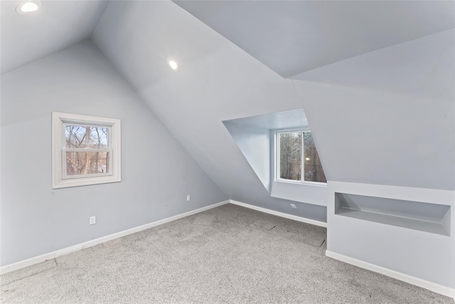 bonus room featuring lofted ceiling, a healthy amount of sunlight, and carpet