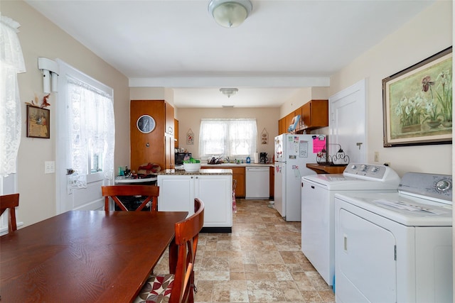 kitchen featuring separate washer and dryer, white cabinets, and white appliances