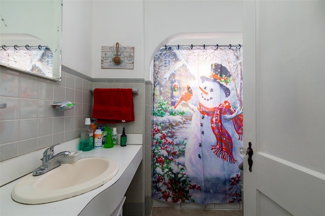 bathroom featuring vanity and tile walls