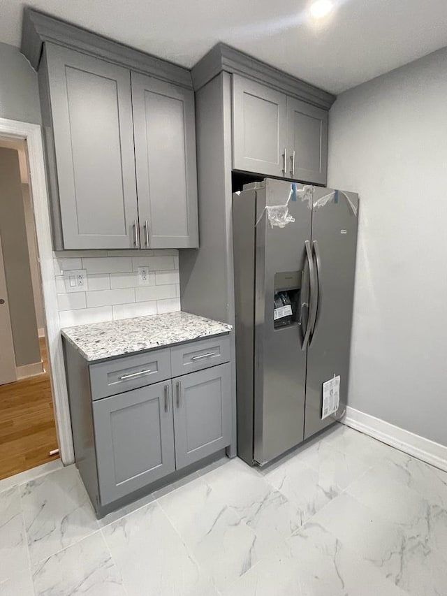 18806 Brinkerhoff Ave, Cambria Heights, NY 11412 - kitchen featuring backsplash, stainless steel fridge, light stone countertops, and gray cabinets