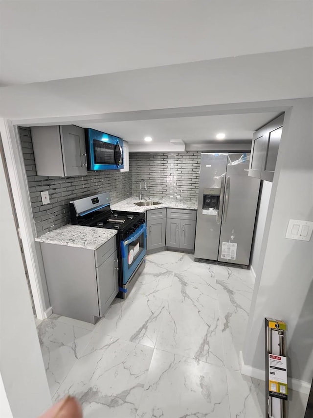 18806 Brinkerhoff Ave, Cambria Heights, NY 11412 - kitchen featuring gray cabinets, appliances with stainless steel finishes, tasteful backsplash, sink, and light stone counters