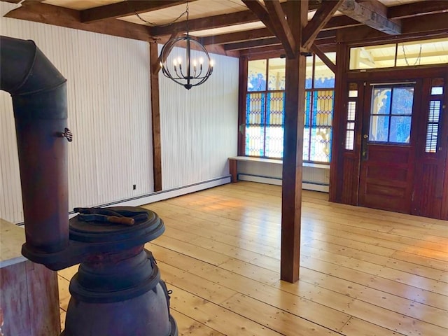 entryway with beamed ceiling, a wealth of natural light, an inviting chandelier, and light wood-type flooring