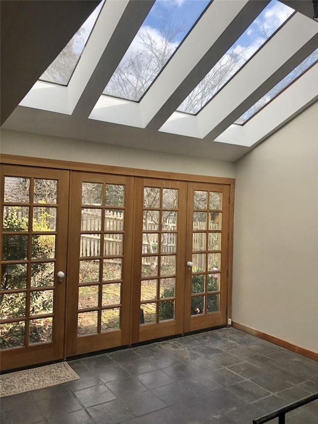 doorway with lofted ceiling with skylight, a healthy amount of sunlight, and french doors