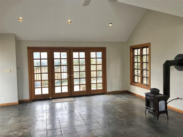 entryway featuring ceiling fan, high vaulted ceiling, and a wood stove