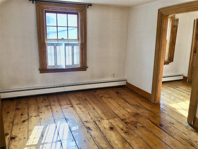 unfurnished room featuring light hardwood / wood-style floors and baseboard heating