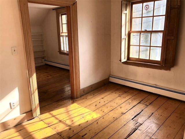 spare room featuring a baseboard radiator and light wood-type flooring