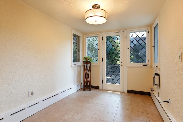 doorway to outside featuring light tile patterned flooring, a baseboard radiator, and a textured ceiling