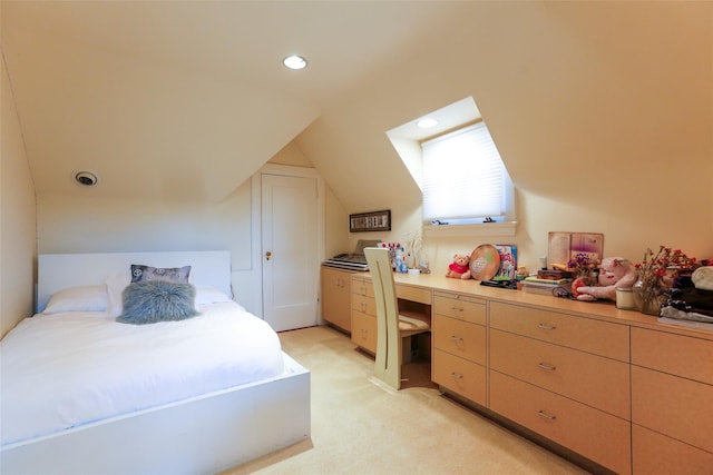 bedroom featuring built in desk, lofted ceiling, and light colored carpet