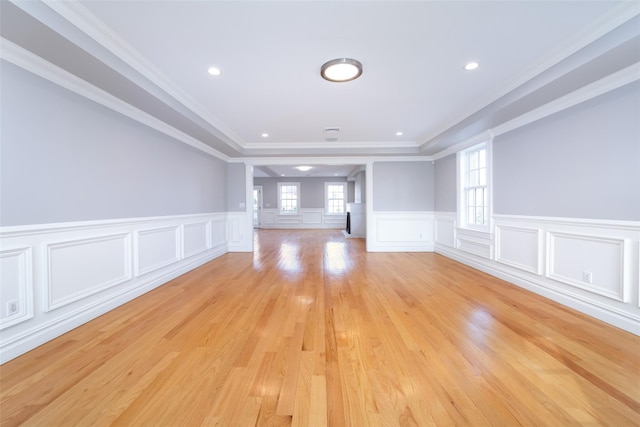 empty room featuring light wood-style floors, ornamental molding, a wainscoted wall, and recessed lighting