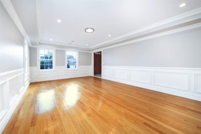 spare room with recessed lighting, a wainscoted wall, crown molding, and light wood-style flooring