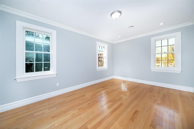 spare room with baseboards, ornamental molding, and a healthy amount of sunlight