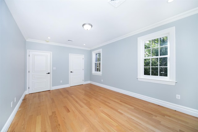 unfurnished room with baseboards, crown molding, visible vents, and a wealth of natural light