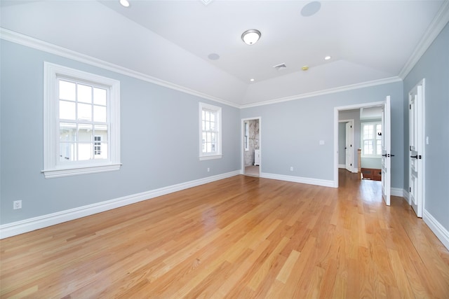 empty room with a healthy amount of sunlight, visible vents, ornamental molding, and vaulted ceiling