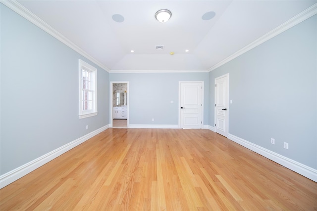 spare room with ornamental molding, light wood-style flooring, and baseboards