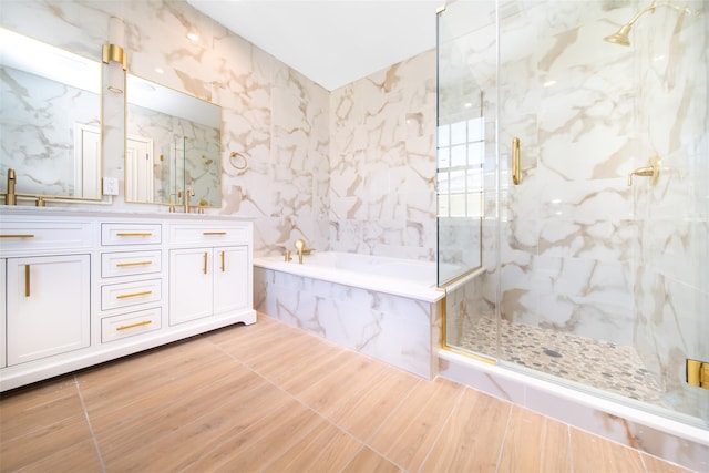 full bath with double vanity, a sink, a marble finish shower, and a bath