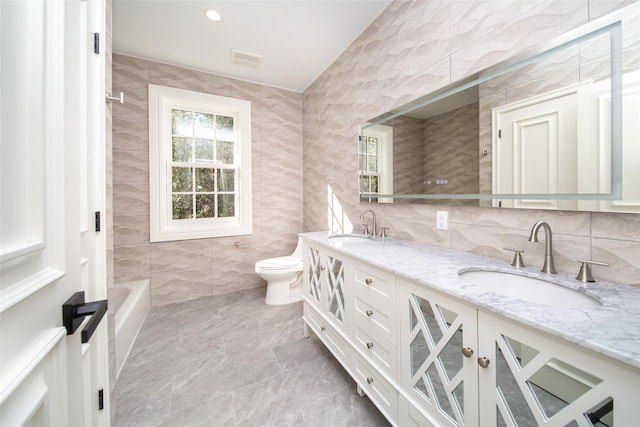 bathroom with visible vents, a sink, tile walls, and double vanity