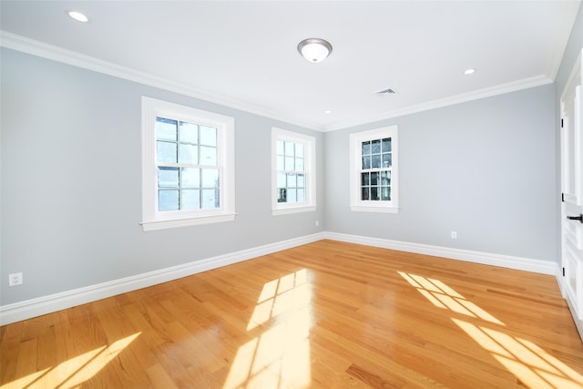 spare room featuring ornamental molding, recessed lighting, light wood-style flooring, and baseboards