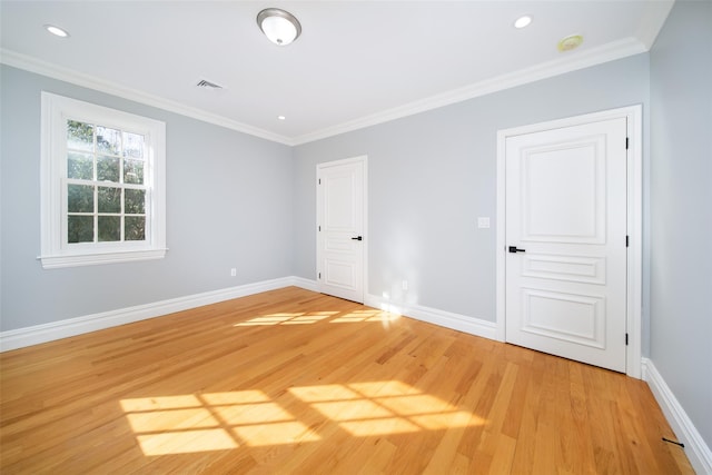 spare room with ornamental molding, wood finished floors, and baseboards