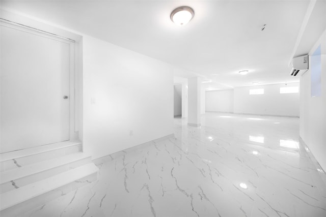 empty room with marble finish floor and a wall mounted AC