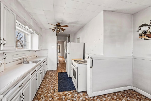 kitchen featuring white range with gas cooktop, sink, white cabinets, and ceiling fan