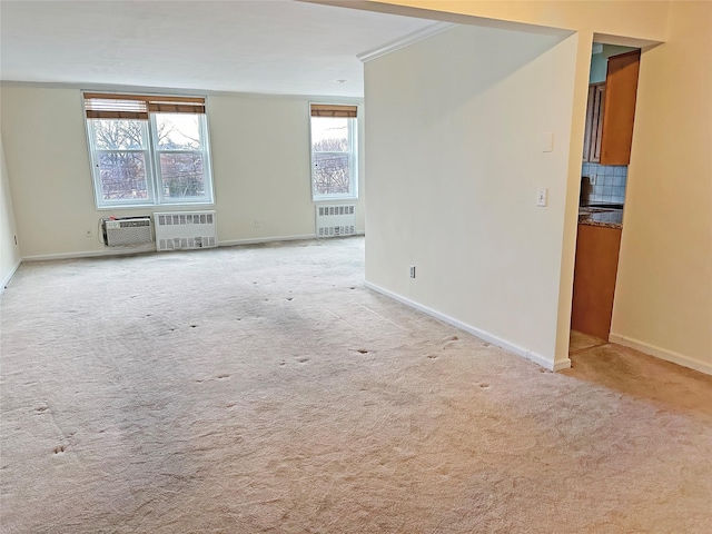 carpeted empty room with a wall mounted air conditioner and radiator heating unit