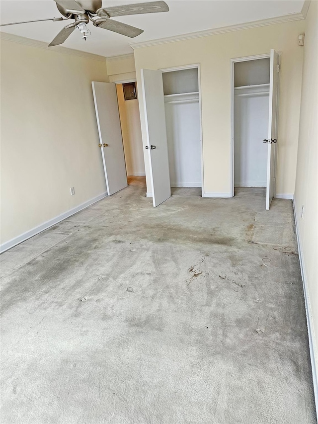 unfurnished bedroom with crown molding, light colored carpet, ceiling fan, and two closets