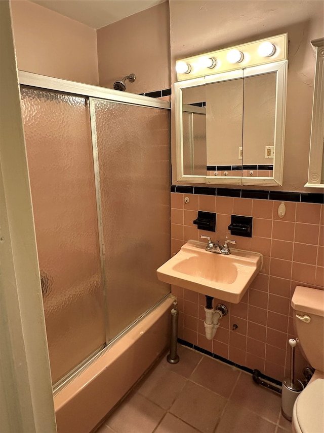 full bathroom featuring sink, tile walls, tile patterned floors, and toilet