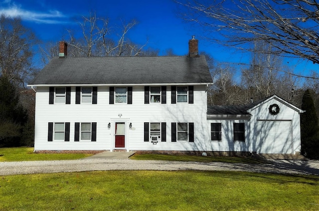 colonial house with a garage and a front yard