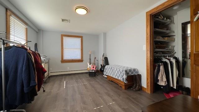 bedroom with wood-type flooring and baseboard heating