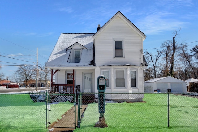 view of front of house featuring an outbuilding, a garage, and a front yard