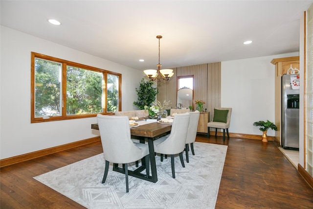 dining area with dark hardwood / wood-style floors and a notable chandelier