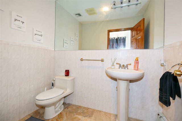 bathroom featuring tile walls, toilet, and baseboard heating