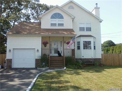 view of front of home with a garage and a front lawn