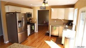 kitchen with white cabinetry, sink, wood-type flooring, and stainless steel appliances