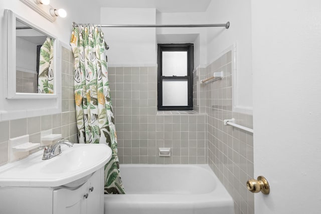 bathroom with shower / tub combo with curtain, vanity, and tile walls