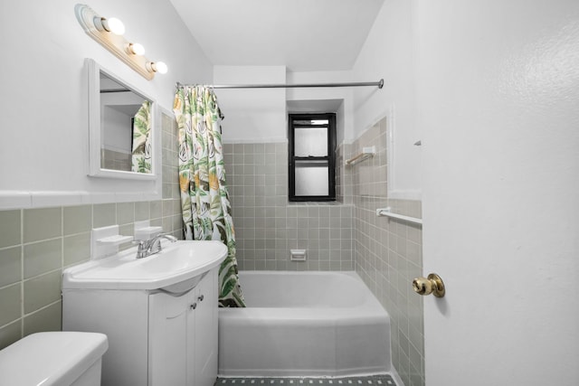 full bathroom with toilet, tile walls, vanity, and shower / bath combo with shower curtain