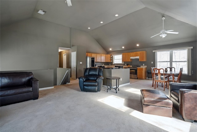 living room featuring ceiling fan, a healthy amount of sunlight, light colored carpet, and high vaulted ceiling