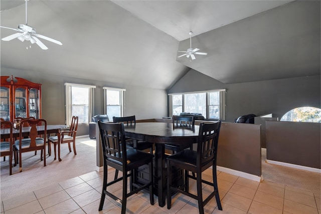 dining area featuring vaulted ceiling, plenty of natural light, light carpet, and ceiling fan