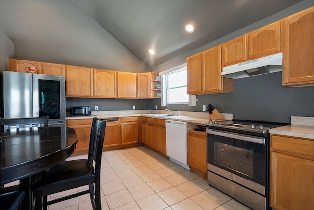 kitchen with lofted ceiling, stainless steel appliances, sink, and light tile patterned floors