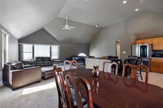 carpeted dining space featuring high vaulted ceiling and ceiling fan