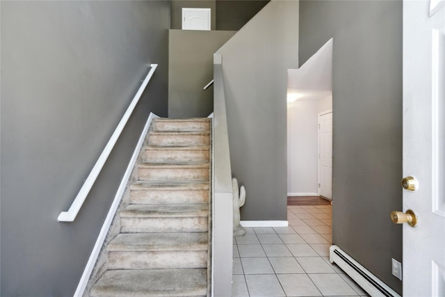 staircase with baseboard heating and tile patterned floors