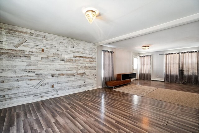 interior space with dark hardwood / wood-style flooring, beam ceiling, and wood walls